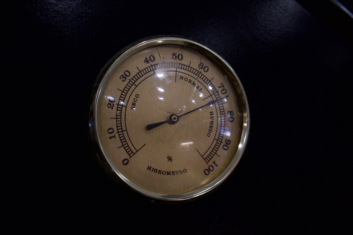 A vintage wall hygrometer photographed head on, its single needle resting part way along a graduated dial, with no people, no clinical or laboratory setting and no readable brand or logo in frame, for the piece on how much a risk score adds to an ordinary check-up